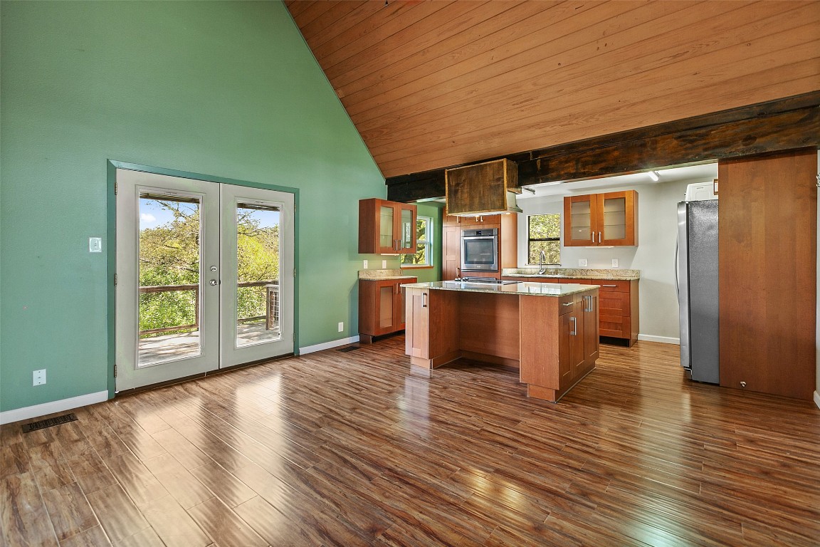 4301 Stearn's Lane Austin, TX 78745 - Photo 9 of 39 an empty room with wooden floor and a kitchen
