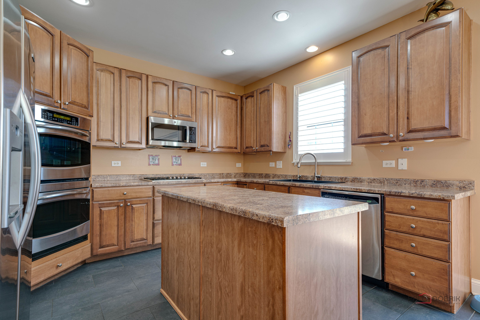 288 Shelbourne Road Volo, IL 60073 - Photo 7 of 33 a kitchen with granite countertop wooden cabinets and a stove