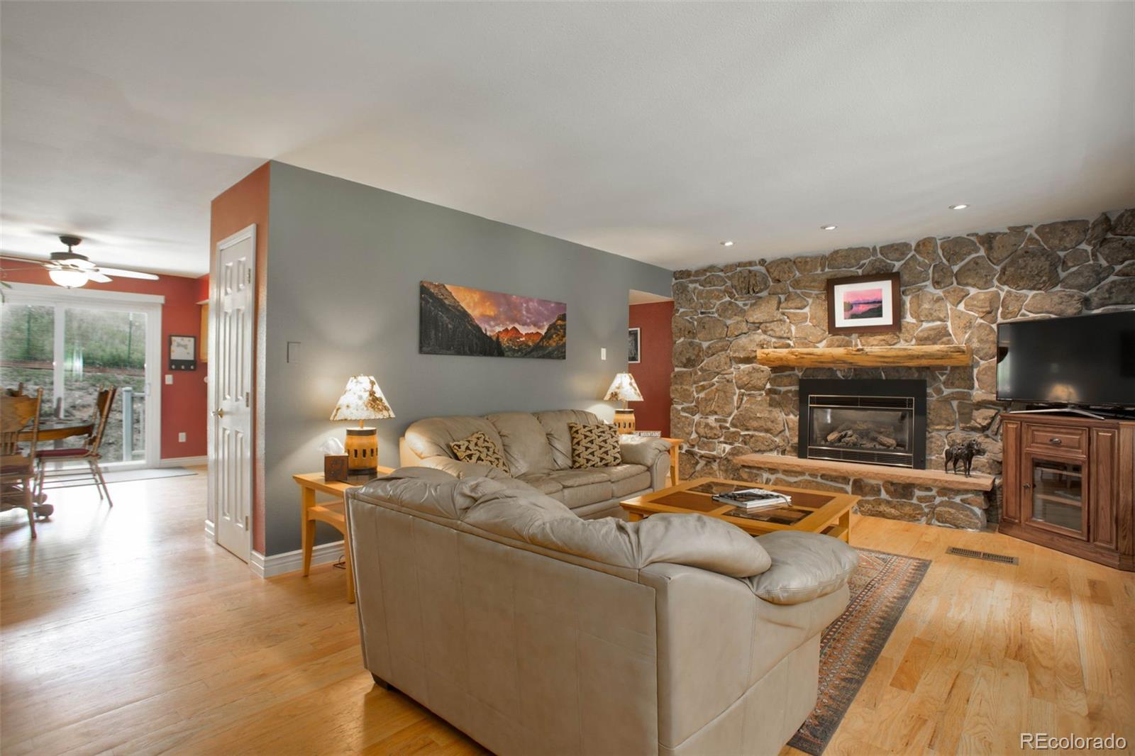 12079 Tecumseh Trail Conifer, CO 80433 - Photo 13 of 38 a living room with furniture a fireplace and a flat screen tv