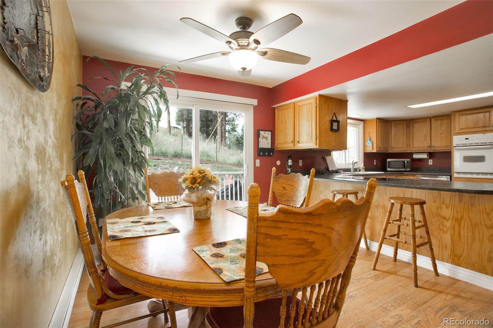 12079 Tecumseh Trail Conifer, CO 80433 - Photo 16 of 38 a dining room with furniture a kitchen view and a chandelier