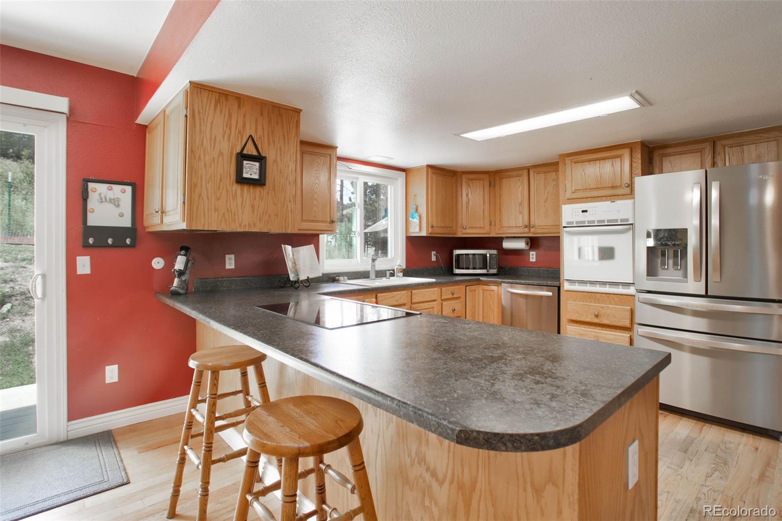 12079 Tecumseh Trail Conifer, CO 80433 - Photo 17 of 38 a kitchen with stainless steel appliances granite countertop a sink a stove and a refrigerator