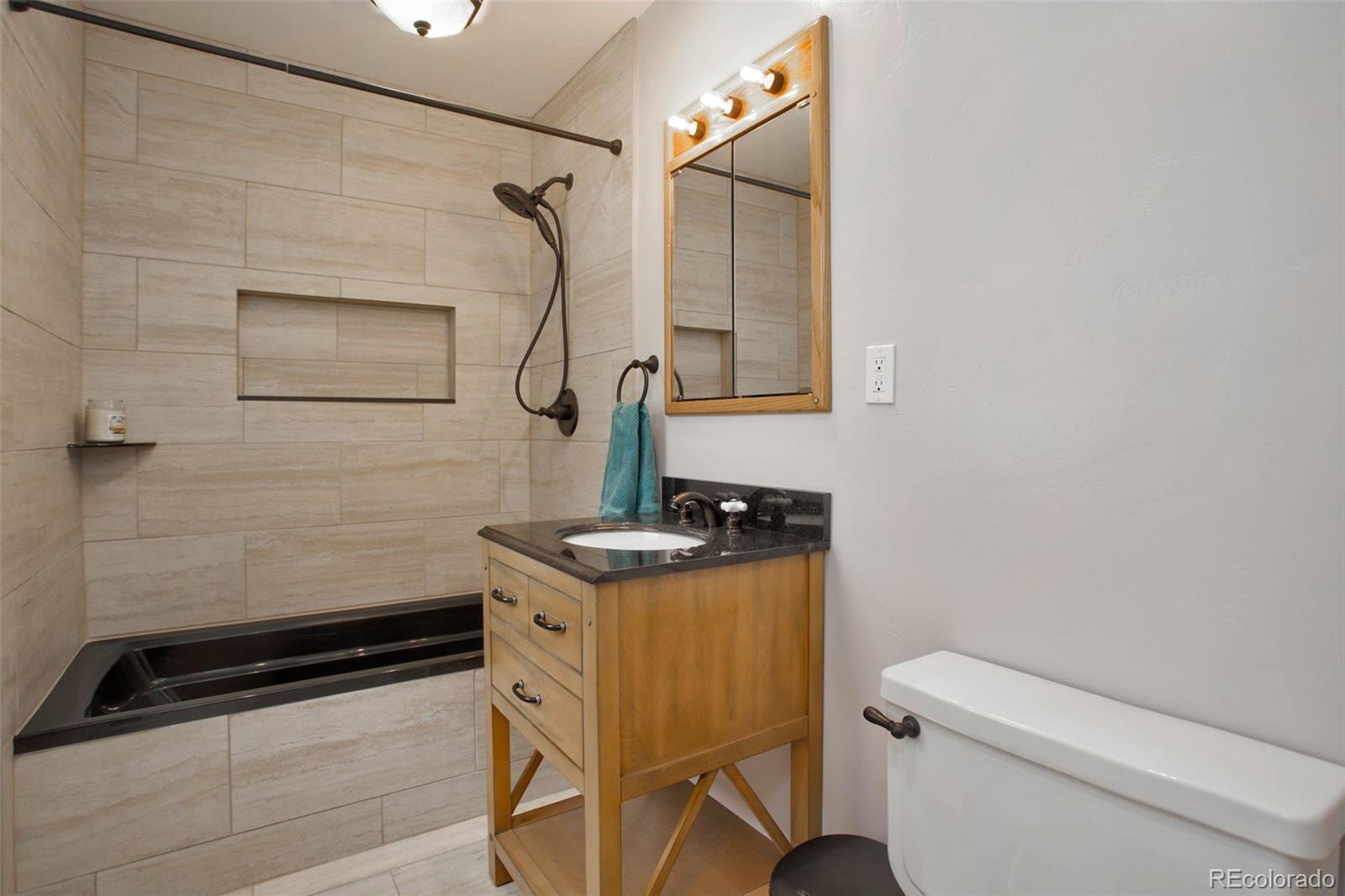 12079 Tecumseh Trail Conifer, CO 80433 - Photo 22 of 38 a bathroom with a sink a toilet and a mirror