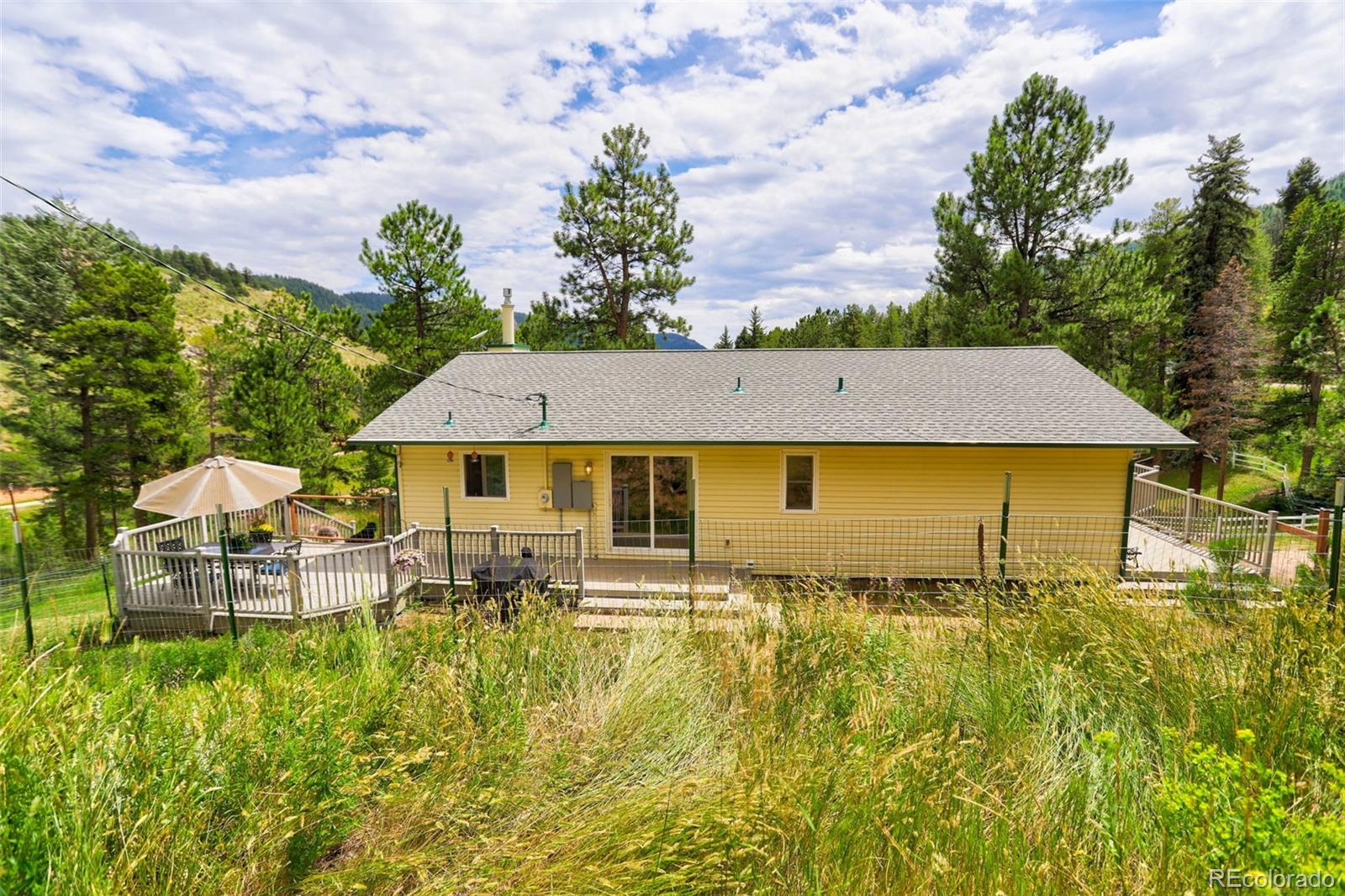 12079 Tecumseh Trail Conifer, CO 80433 - Photo 26 of 38 a aerial view of a house with table and chairs under an umbrella