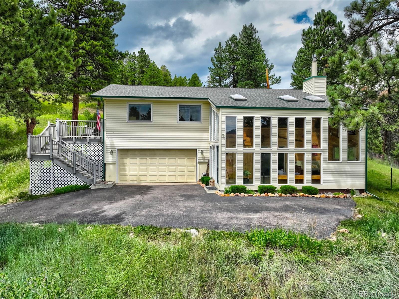 12079 Tecumseh Trail Conifer, CO 80433 - Photo 6 of 38 a front view of a house with a garden
