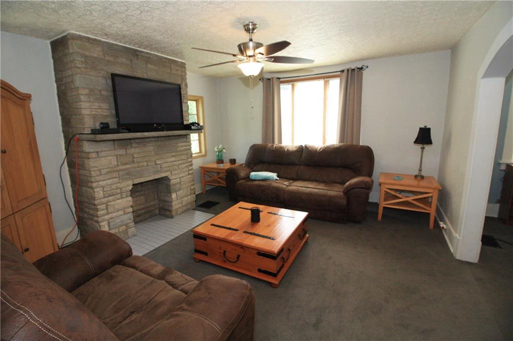 The living room has a lovely decorative stone fireplace that is a great focal point to plan your furniture around.