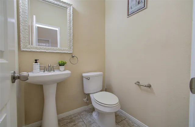 a bathroom with a sink mirror and toilet