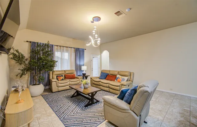 a living room with furniture a chandelier and a rug