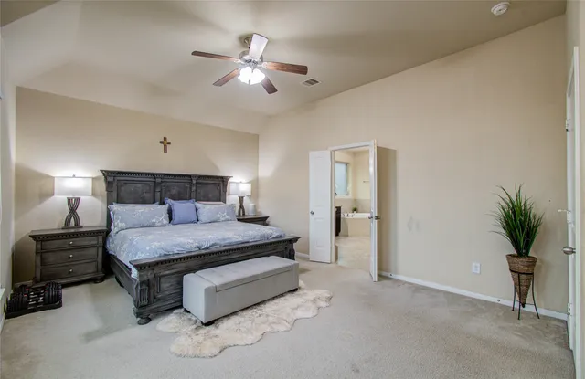 a spacious bedroom with a bed and a chandelier