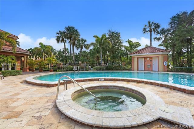 100 Uno Lago Drive, Unit 205 Juno Beach, FL 33408 - Photo 12 of 13 a swimming pool with outdoor seating yard and barbeque oven