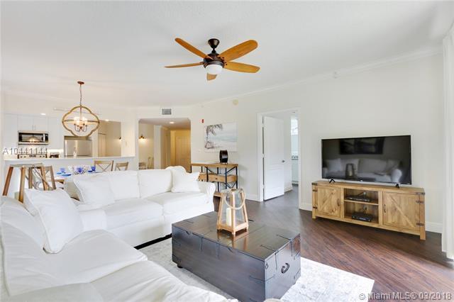 100 Uno Lago Drive, Unit 205 Juno Beach, FL 33408 - Photo 4 of 13 a living room with furniture and a flat screen tv