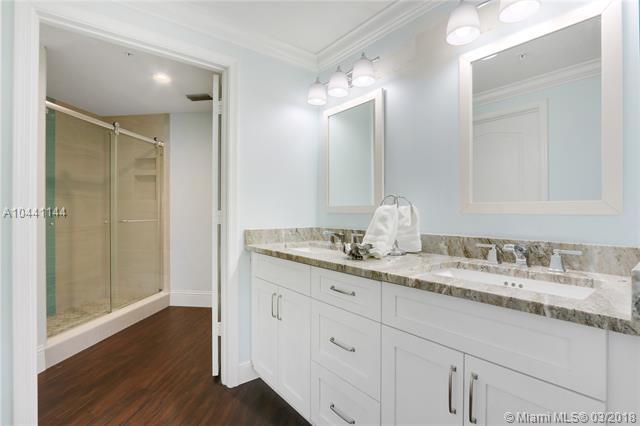 100 Uno Lago Drive, Unit 205 Juno Beach, FL 33408 - Photo 8 of 13 a bathroom with a granite countertop sink a mirror and a shower