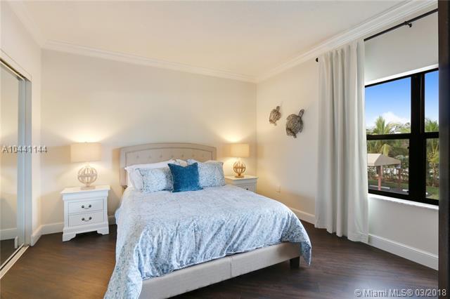 100 Uno Lago Drive, Unit 205 Juno Beach, FL 33408 - Photo 9 of 13 a bedroom with a bed and large window