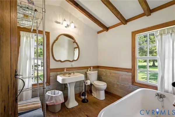 a bathroom with a tub mirror and window