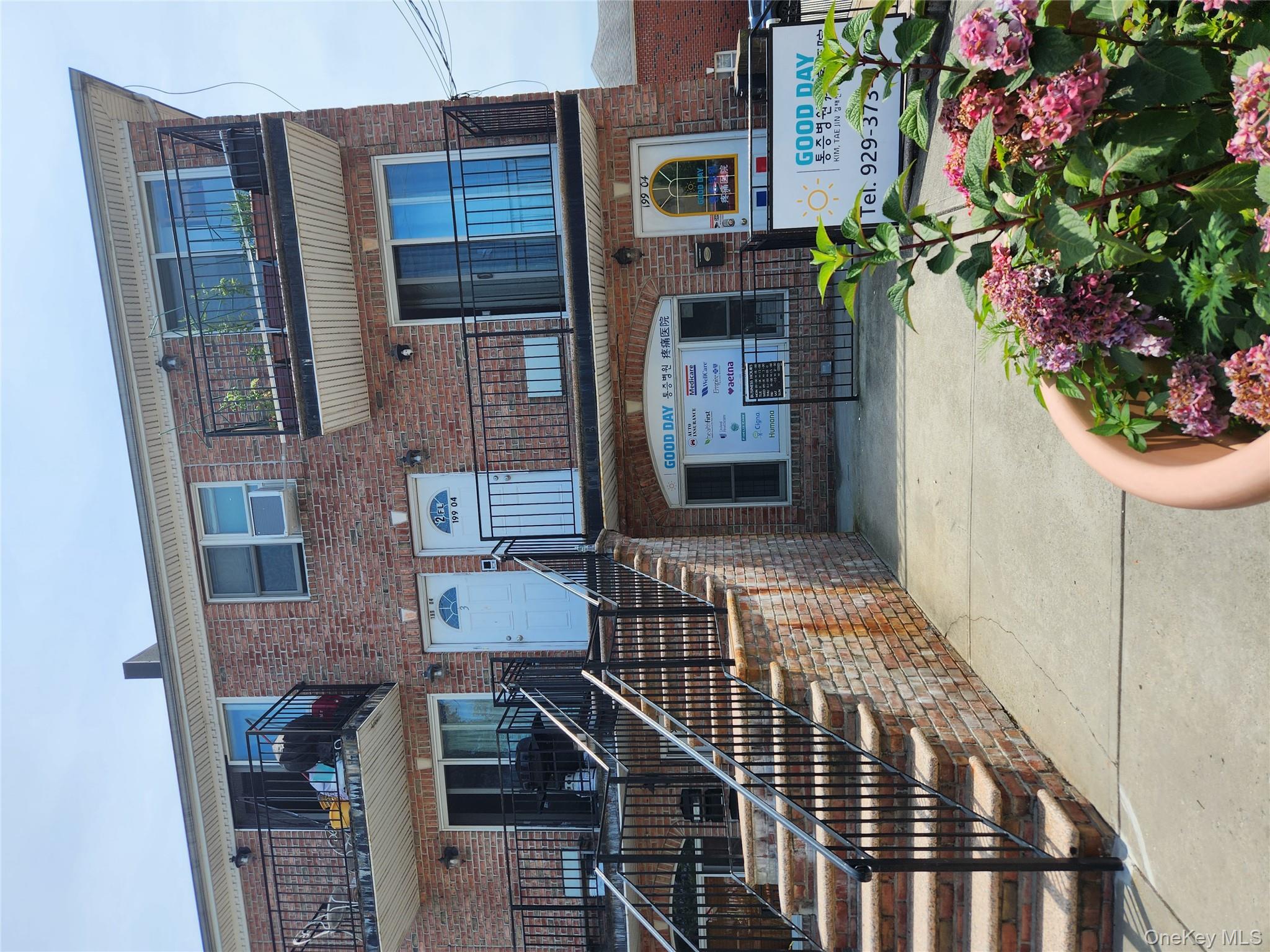 199-04 47th Avenue Queens, NY 11358 - Photo 2 of 5 a front view of a house with a garden