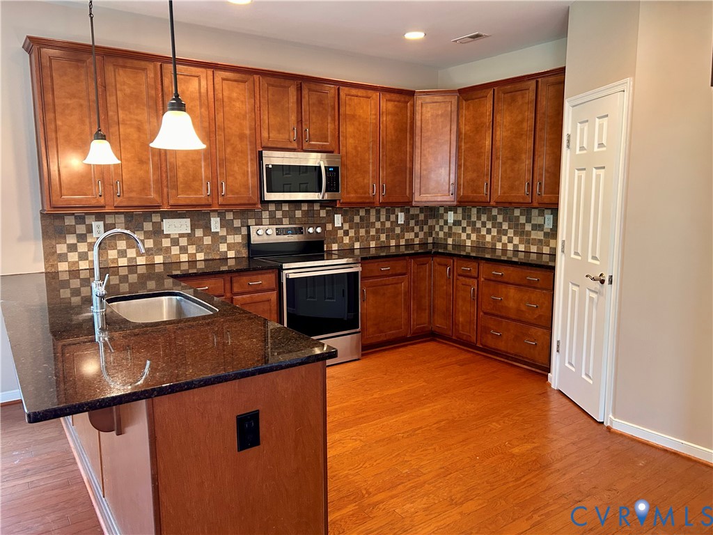 14537 Parracombe Lane Midlothian, VA 23112 - Photo 20 of 50 a kitchen with stainless steel appliances granite countertop a stove a sink and a microwave