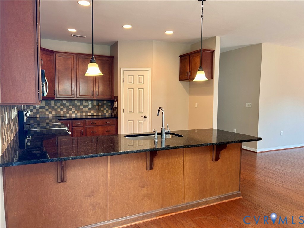 14537 Parracombe Lane Midlothian, VA 23112 - Photo 21 of 50 a kitchen with kitchen island granite countertop a sink a counter top space and cabinets