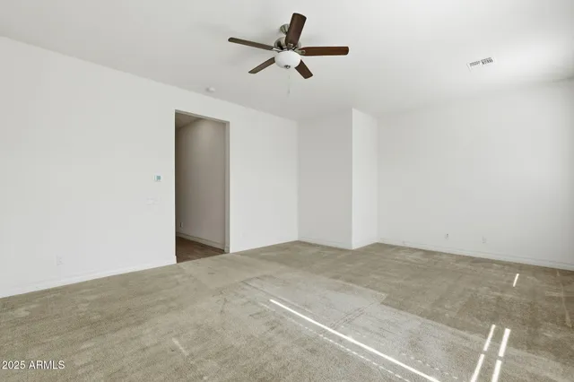 a view of a big room with windows and chandelier fan