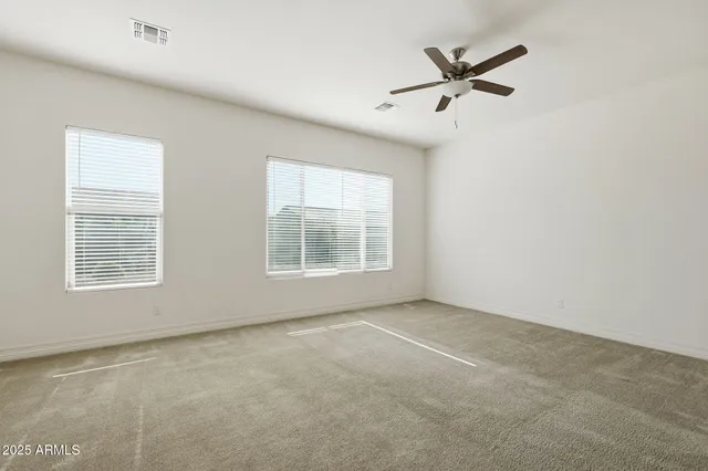 a view of an empty room with a window and a ceiling fan