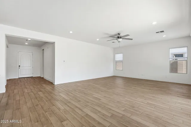 a view of a livingroom with furniture hardwood floor and ceiling fan