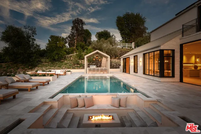 a view of swimming pool with couches and wooden floor