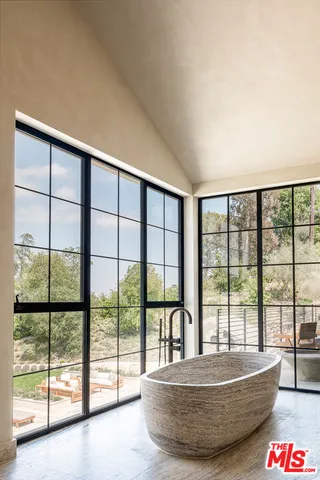 a living room with a large window and walk in balcony