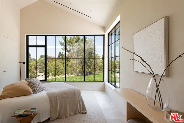 a bedroom with a bed and a large window