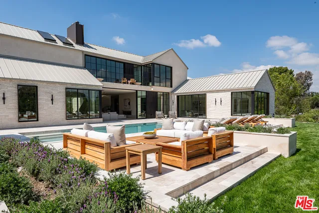 a view of a house with swimming pool and furniture