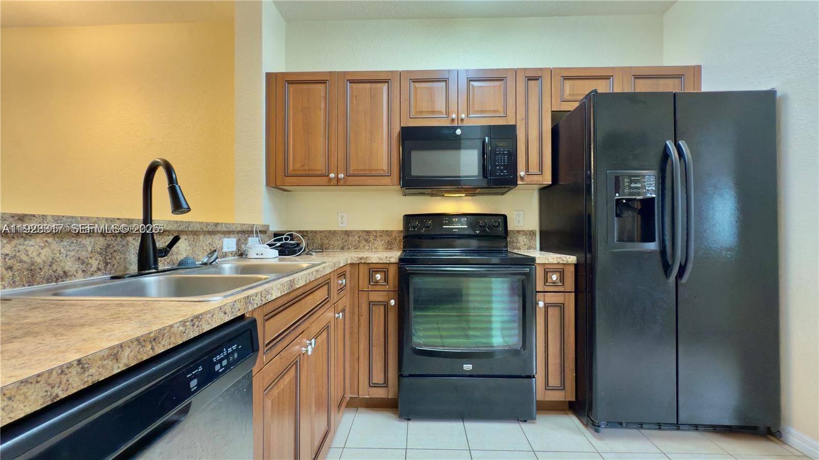 1918 Alamanda Way Riviera Beach, FL 33404 - Photo 4 of 23 a kitchen with stainless steel appliances granite countertop a refrigerator a stove and a sink