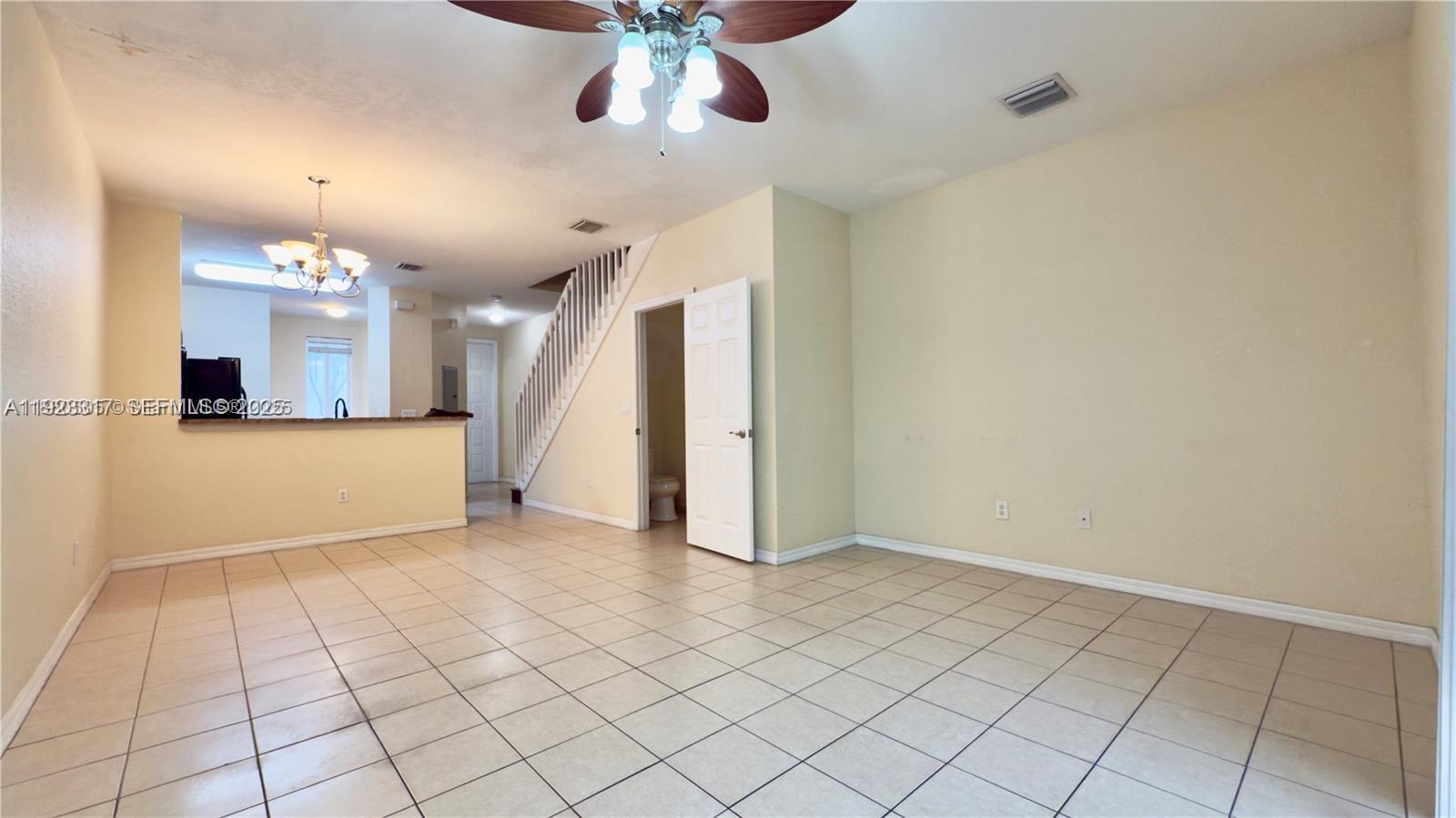 1918 Alamanda Way Riviera Beach, FL 33404 - Photo 6 of 23 an empty room with kitchen and chandelier fan