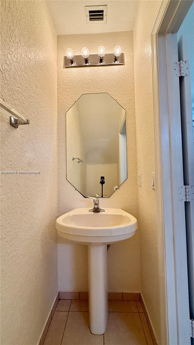 1918 Alamanda Way Riviera Beach, FL 33404 - Photo 7 of 23 a bathroom with a sink and mirror