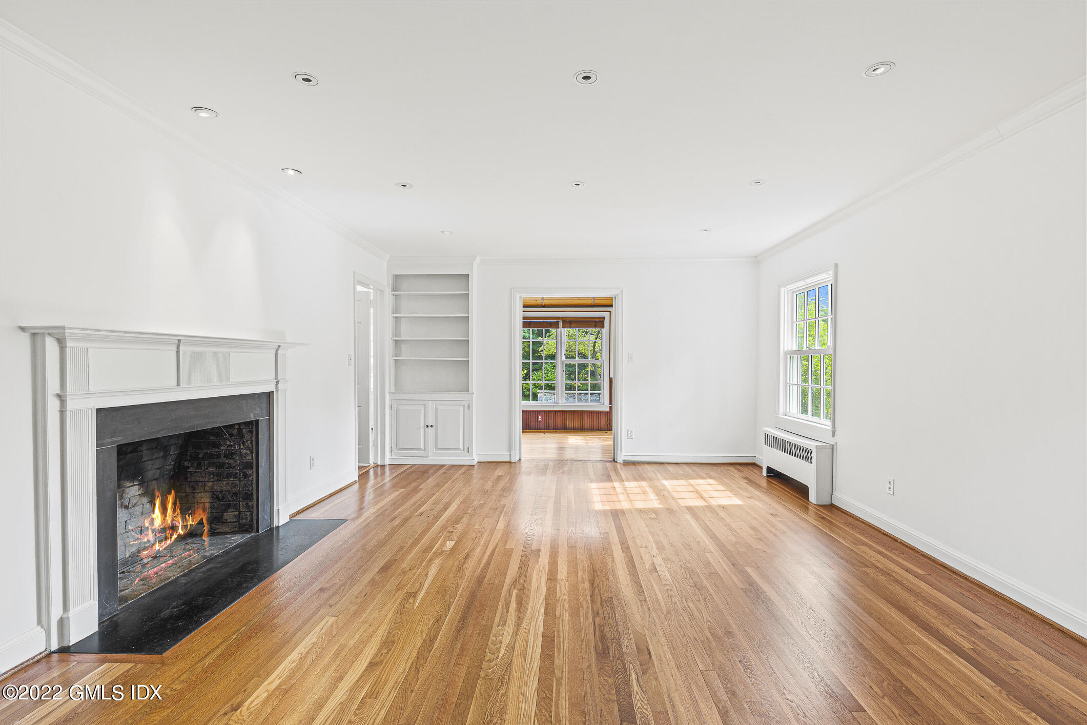 65 Doubling Road Greenwich, CT 06830 - Photo 4 of 18 a view of an empty room with wooden floor fireplace and a window