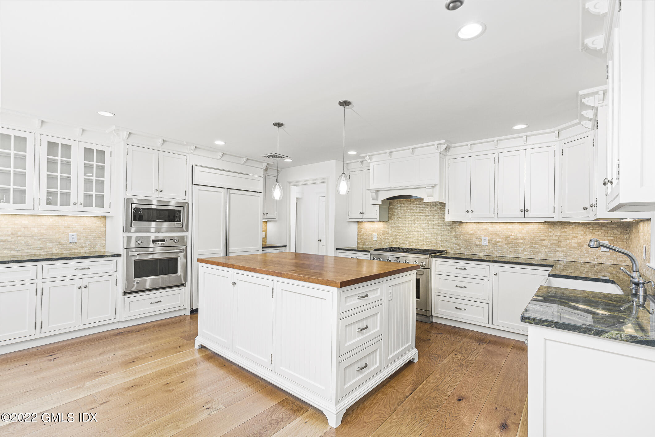 65 Doubling Road Greenwich, CT 06830 - Photo 8 of 18 a kitchen with granite countertop a stove oven and white cabinets
