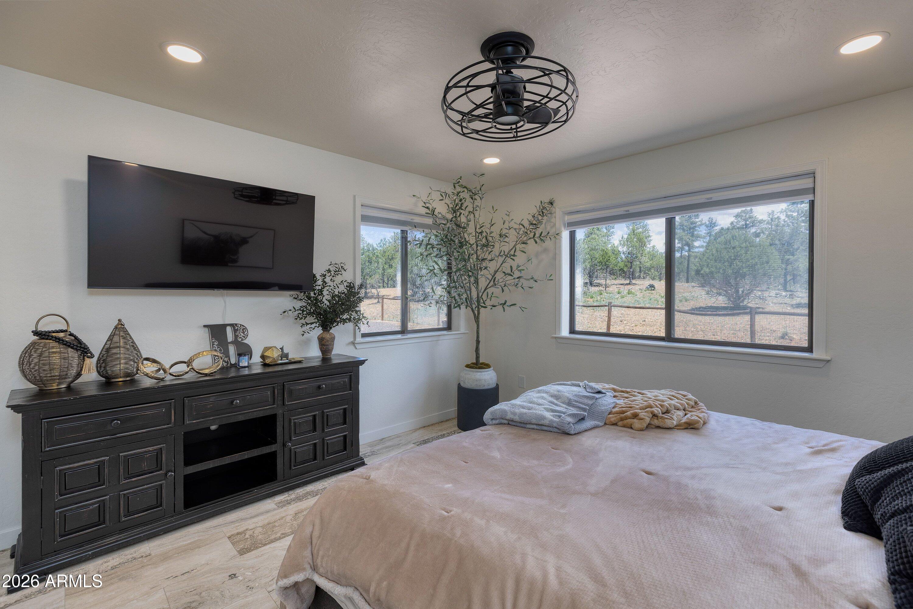 5182 Pinedale Wash Road Pinedale, AZ 85934 - Photo 24 of 54 a bedroom with a large bed and a flat screen tv