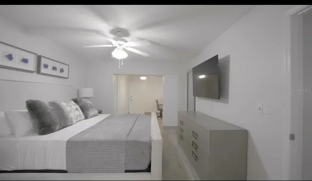 a bedroom with a bed and a ceiling fan