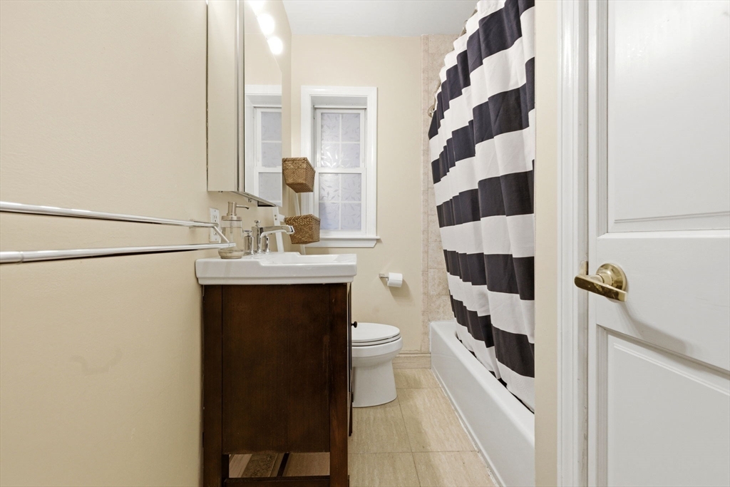27 Commonwealth Avenue, Unit 1 Newton, MA 02467 - Photo 13 of 18 a bathroom with a sink a toilet a shower and a mirror