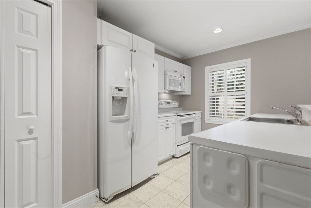 27 Commonwealth Avenue, Unit 1 Newton, MA 02467 - Photo 3 of 18 a kitchen with white cabinets and white appliances