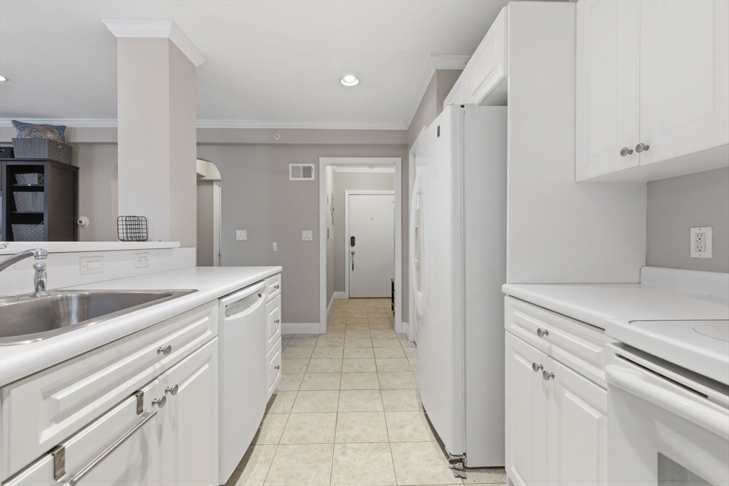 27 Commonwealth Avenue, Unit 1 Newton, MA 02467 - Photo 5 of 18 a view of a kitchen with white cabinets