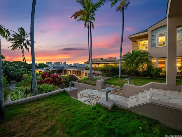 a view of a house with a yard and potted plants