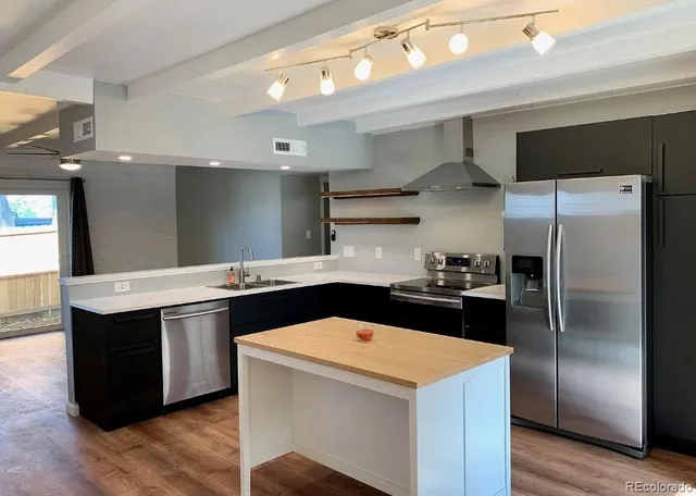an open kitchen with wooden floor and mirrors