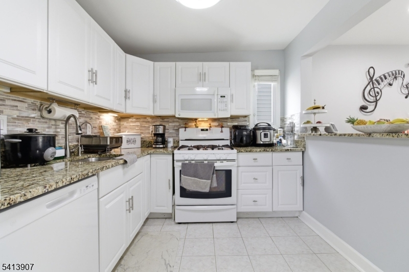 32 Cedar Avenue Elizabeth, NJ 07202 - Photo 5 of 32 a kitchen with granite countertop white cabinets and white appliances