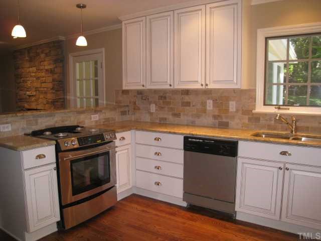 704 Davidson Street Raleigh, NC 27609 - Photo 4 of 12 a kitchen with granite countertop white cabinets and white appliances