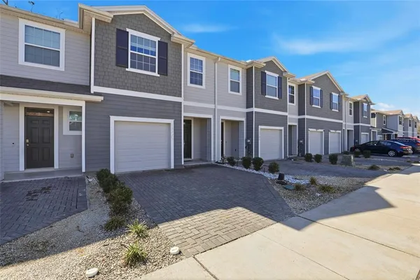 a front view of a house with yard and trees