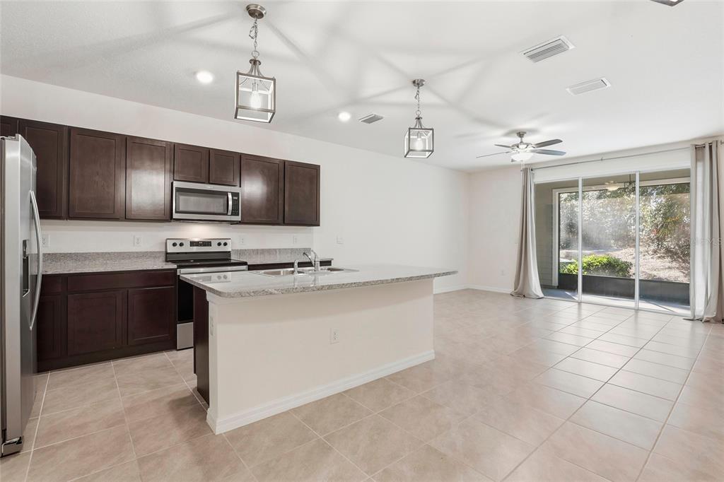 13775 Northwest 9th Road Newberry, FL 32669 - Photo 14 of 33 a open kitchen with stainless steel appliances granite countertop a stove and a sink with cabinets
