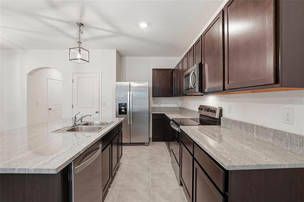 13775 Northwest 9th Road Newberry, FL 32669 - Photo 16 of 33 a kitchen with stainless steel appliances granite countertop counter space a sink and cabinets