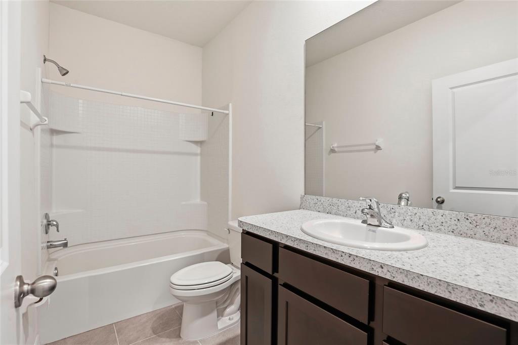 13775 Northwest 9th Road Newberry, FL 32669 - Photo 19 of 33 a bathroom with a granite countertop sink toilet and shower