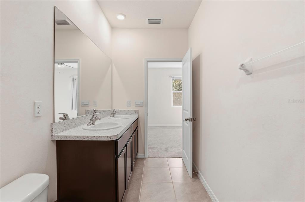 13775 Northwest 9th Road Newberry, FL 32669 - Photo 22 of 33 a en suite bathroom with a sink a toilet a mirror and shower