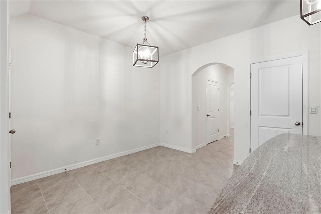 13775 Northwest 9th Road Newberry, FL 32669 - Photo 6 of 33 an empty room with a chandelier fan and wooden floor