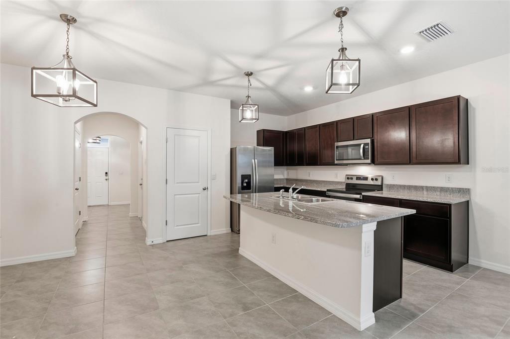 13775 Northwest 9th Road Newberry, FL 32669 - Photo 7 of 33 a kitchen with stainless steel appliances granite countertop a sink a stove and a refrigerator