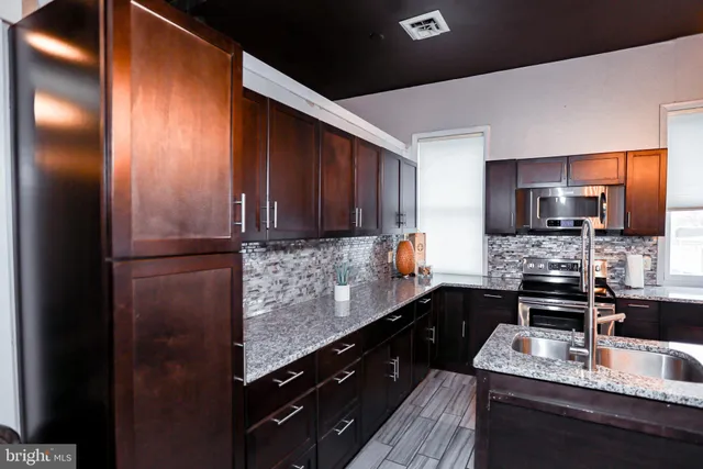 a living room with furniture a flat screen tv and kitchen view