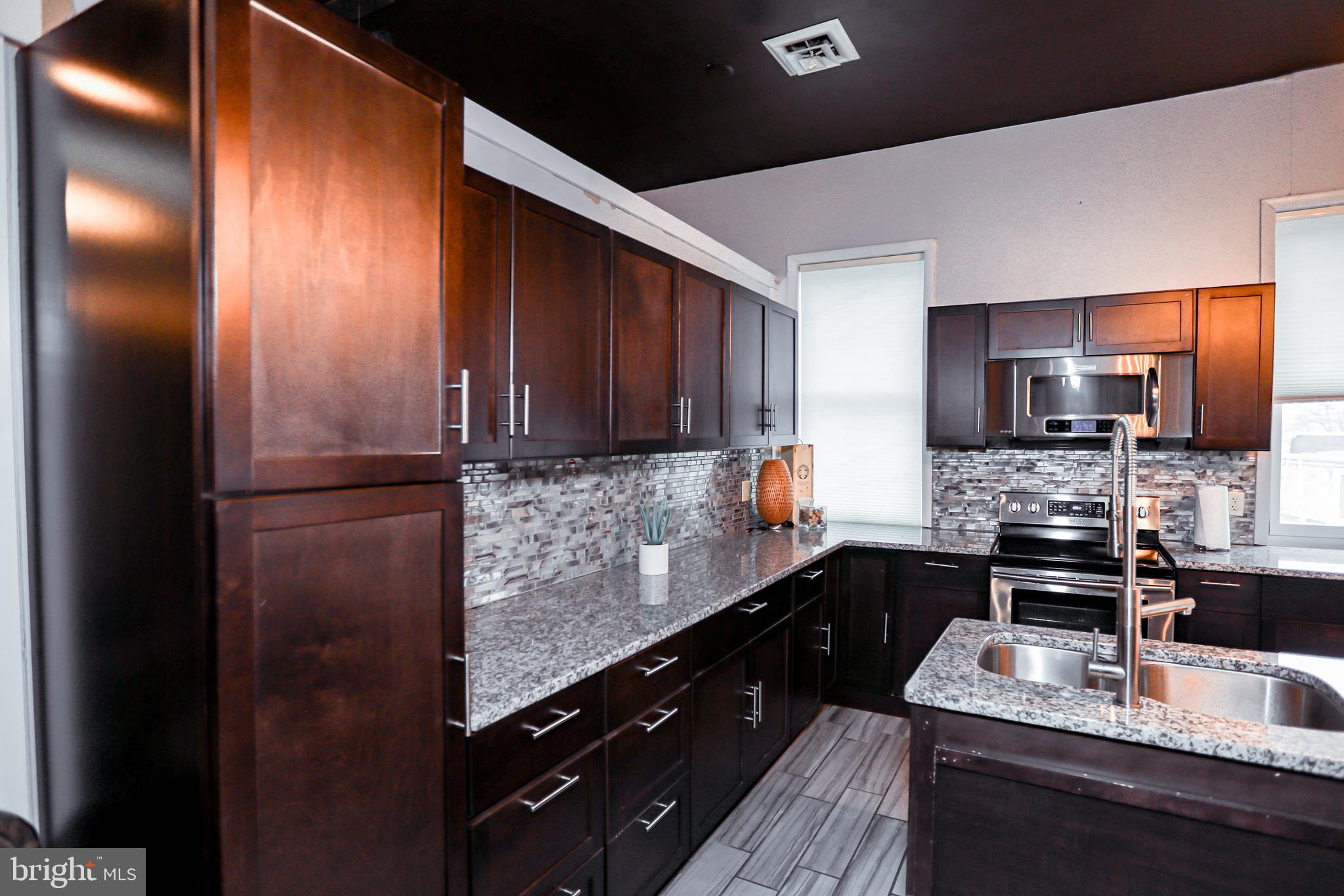 933 Rose Street Harrisburg, PA 17102 - Photo 17 of 98 a kitchen with granite countertop stainless steel appliances and wooden cabinets